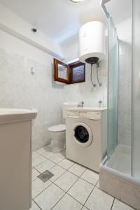 ein Badezimmer mit einer Waschmaschine und einem WC in der Unterkunft Apartments with a parking space Mrljane, Pasman - 20056 in Pašman