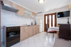 a kitchen with a stove and a table in it at Apartments with parking space Mrljane, Pasman - 20056 in Pašman
