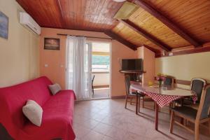 a living room with a red couch and a table at Apartments by the sea Grebastica, Sibenik - 20736 in Grebaštica
