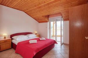 a bedroom with a bed with a red blanket at Apartments by the sea Grebastica, Sibenik - 20736 in Grebaštica