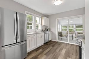 a kitchen with white cabinets and a stainless steel refrigerator at Stylish, Relaxing & Comfy 3 BDR Home in Bristol