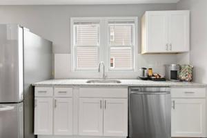 a white kitchen with a sink and a refrigerator at Stylish, Relaxing & Comfy 3 BDR Home in Bristol