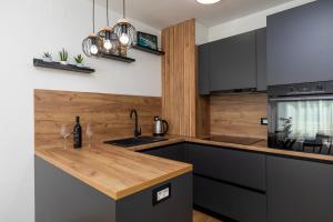 uma cozinha com armários pretos e um balcão de madeira em Apartments with WiFi Karlovac - 20990 em Karlovac
