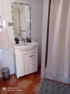 een badkamer met een witte wastafel en een spiegel bij Aldea Biocultural Ayelen in Piedra Lisa