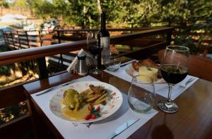 a table with a plate of food and glasses of wine at Tekoa Lodge in Puerto Iguazú