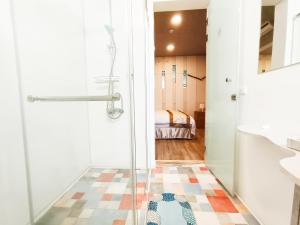 um banheiro com chuveiro e porta de vidro em Yu Hsuan Homestay em Taitung City