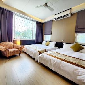 a hotel room with two beds and a chair at Yu Hsuan Homestay in Taitung City