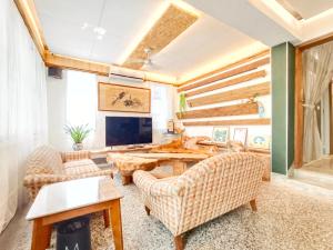 uma sala de estar com mesa, cadeiras e uma TV em Yu Hsuan Homestay em Taitung City