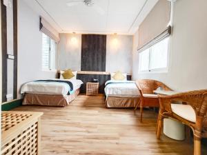 台東市的住宿－遇軒民宿，一间设有两张床和一张桌子及椅子的房间