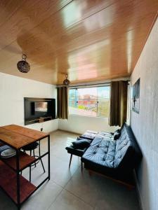 Ubud Apartments Praia do Frances في برايا دو فرانسيس: غرفة معيشة مع أريكة وطاولة
