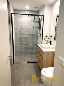 a bathroom with a shower and a toilet and a sink at Braddon 1BD - Walk to Cafés, Secure Parking in Canberra +15 photos