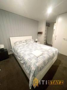 a bedroom with a large bed in a room at Braddon 1BD - Walk to Cafés, Secure Parking in Canberra