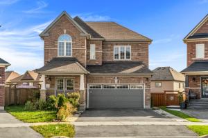 a brick house with a garage at Elevate Your Family Getaway in Oshawa with the brand new Luxury Villa in Oshawa