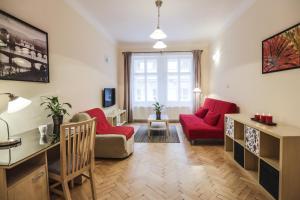 a living room with two red chairs and a desk at Accommodation Smečky 14 in Prague