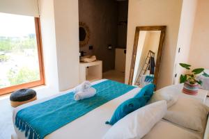 una camera da letto con un letto con due peluche sopra di Tikul Hotel Boutique a Isola Holbox