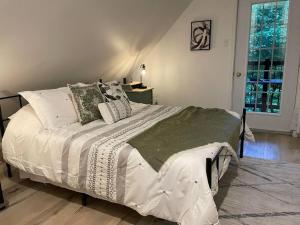 een slaapkamer met een groot bed met witte lakens en kussens bij Évadez-vous à Grandes-Piles in Grandes-Piles