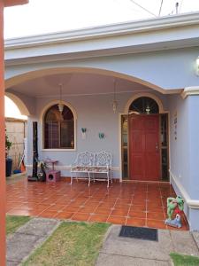 馬那瓜的住宿－Acogedora Casa，一座房子,设有红色的门,在庭院里设有长凳