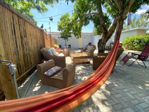 een hangmat in een achtertuin met meubilair en een hek bij PARADISE II MIAMI BEACH HOUSE in Miami
