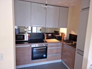 a kitchen with white cabinets and a stove top oven at Clearwater Apartment in Dublin