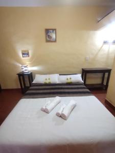 a bedroom with a bed with two slippers on it at La Casa de la Abuela Tilcara in Tilcara