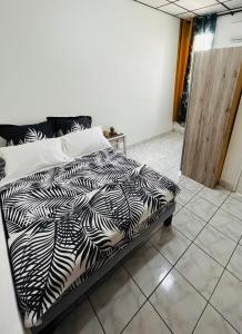 a black and white bed in a room at O’Rythme du KA in Pointe-à-Pitre
