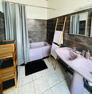 a bathroom with a tub and a sink and a bath tub at O’Rythme du KA in Pointe-à-Pitre