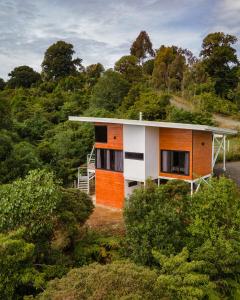 uma casa no topo de uma colina com árvores em Casa de montaña Arisa em Cartago