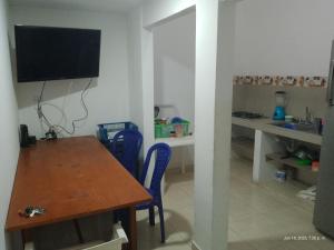 een eetkamer met een tafel en een televisie aan de muur bij Casa Shangai 3 in Santa Marta