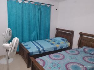 een slaapkamer met 2 bedden en een blauw gordijn bij Casa Shangai 3 in Santa Marta