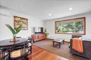 a living room with a table and a television at Valley House in Margaret River Town