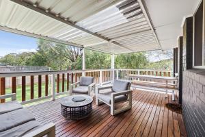 a porch with two chairs and a table on a deck at Valley House in Margaret River Town