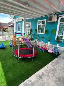 une cour avec une aire de jeux en face d'une maison dans l'établissement Casa De Rose KUBANG KERIAN, à Kota Bharu
