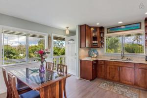 une cuisine avec une table et un vase de fleurs. dans l'établissement Last Minute Opening! Island Style Homebase 2BR 1BA AC Full Kitchen, à Kailua