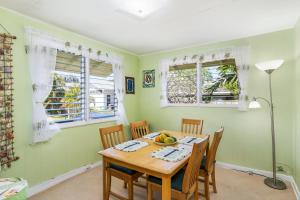 a dining room with a table and chairs and windows at Last Minute Deal! Stunning 2-Bedroom Beachfront House with AC in Kailua