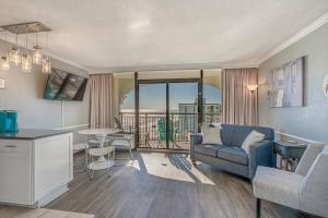 a living room with a couch and a table with a view at Caravelle Resort in Myrtle Beach