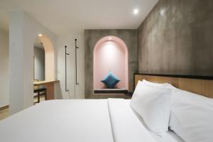 a bedroom with a large white bed and a bathroom at The Bayou Hotel Langkawi in Pantai Cenang