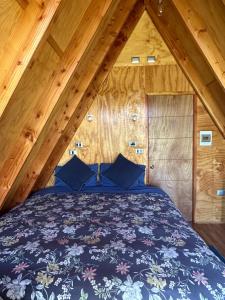 ein Schlafzimmer mit einem Bett im Dachgeschoss in der Unterkunft A-FRAME CABIN PUCON in Pucón