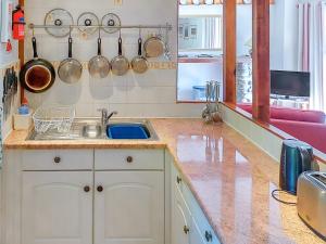 a kitchen with a sink and a counter with pots and pans at Hunt Cottage in Sharrington