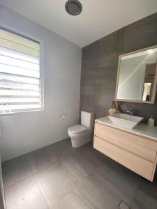 a bathroom with a toilet and a sink and a mirror at Ranch Retreat in Kewarra Beach