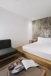 a bedroom with a bed and a chair and a table at The Bayou Hotel Langkawi in Pantai Cenang