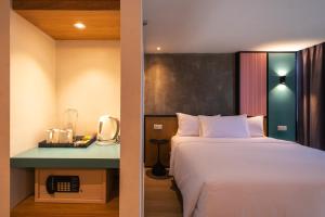a hotel room with a bed and a telephone at The Bayou Hotel Langkawi in Pantai Cenang