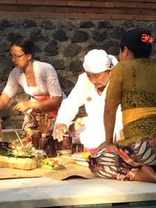 un grupo de personas de pie alrededor de una mesa con comida en Rumah Kelapa Senang, en Karangasem