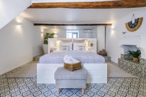 1 dormitorio con 1 cama blanca y 1 silla en Swift View, en Panormos Skopelos