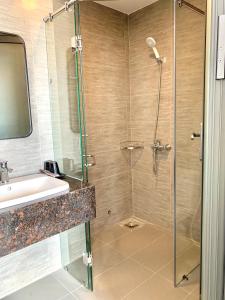 uma casa de banho com um chuveiro e um lavatório. em Luu Gia Hotel em Nha Trang