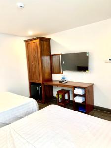 a hotel room with two beds and a desk at Luu Gia Hotel in Nha Trang