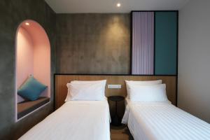 two beds sitting next to each other in a room at The Bayou Hotel Langkawi in Pantai Cenang