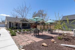 un patio avec des chaises et des parasols dans un jardin dans l'établissement Modern Luxury Bungalow steps from DT Activities, à Rapid City