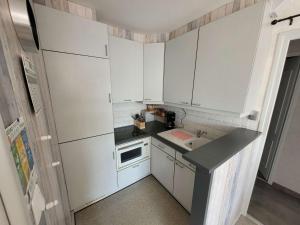 eine kleine Küche mit weißen Schränken und einem Waschbecken in der Unterkunft Appartement Wimereux, 2 pièces, 2 personnes - FR-1-675-24 in Wimereux