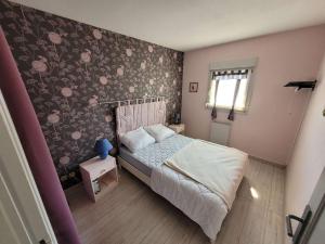 ein kleines Schlafzimmer mit einem Bett und Blumentapete in der Unterkunft Appartement Wimereux, 2 pièces, 2 personnes - FR-1-675-24 in Wimereux