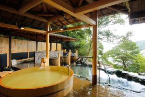 a large wooden tub in a building with a pool at Todaya in Toba